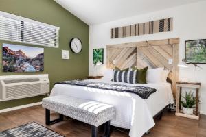 a bedroom with a white bed and a clock on the wall at Red Rock Inn Cottages in Springdale