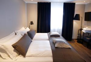 a large bed in a bedroom with a large window at Keflavik Micro Suites in Keflavík