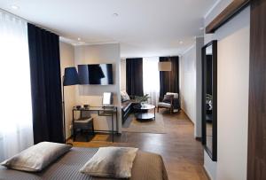 a bedroom with a bed and a desk and a living room at Keflavik Micro Suites in Keflavík