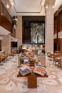 um átrio de um hotel com mesas e cadeiras em Hyatt Regency Delhi em Nova Deli