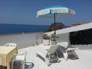 a patio with a table and chairs and an umbrella at Hotel Mareblu in Amantea