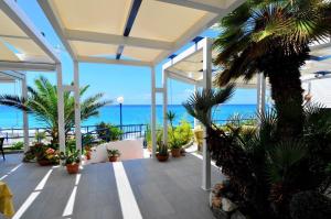 a patio with plants and the ocean in the background at Hotel Mareblu in Amantea