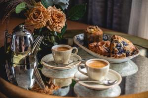 een tafel met kopjes koffie en een bord eten bij Drey Hotel in Dallas