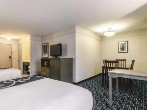 La Quinta by Wyndham Kansas City Airport في كانساس سيتي: غرفة فندقية بسريرين ومكتب وتلفزيون