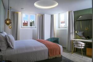 1 dormitorio con cama, escritorio y espejo en São Vicente Alfama Hotel by TRIUS Hotels, en Lisboa