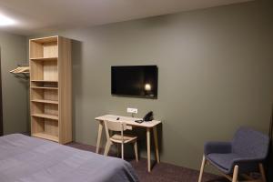 a room with a bed and a table and a tv at Basalt Hotel in Borgarnes