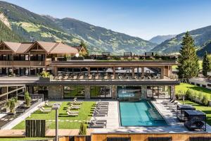 迈尔霍芬Hotel Berghof Mayrhofen GmbH的一座带游泳池和山脉的度假村