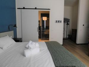 een slaapkamer met een wit bed en handdoeken bij Piumaviola Beds & Apartments in Parma