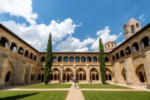 巴尔武埃纳德杜埃罗Castilla Termal Monasterio de Valbuena的一座有树木和草地的建筑的庭院