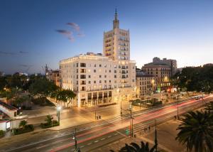 une ville avec un bâtiment et une rue la nuit dans l'établissement Only YOU Hotel Málaga, à Malaga