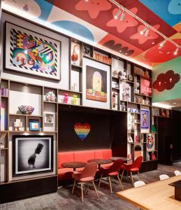 a restaurant with a tv and tables and chairs at citizenM San Francisco Union Square in San Francisco