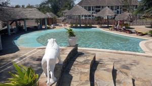 uma estátua de um tubarão ao lado de uma piscina em Lily Palm Resort em Watamu