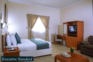 una camera d'albergo con letto e TV di Al Seef Hotel a Sharjah