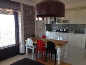 uma cozinha com uma mesa de madeira e cadeiras vermelhas em Derya Beach Apartment em Kas