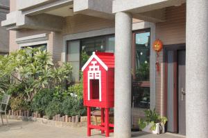 a small red house sitting in front of a building at 八八小屋心享民宿 in Jinning