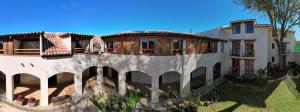 een groot wit gebouw met een boom ervoor bij Hotel Junvay in San Cristóbal de Las Casas