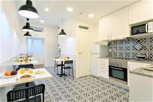 a kitchen with white cabinets and a table with food on it at Suites Amália Guesthouse near Rossio Square in Lisbon