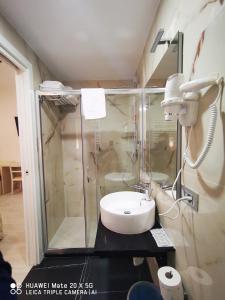 La salle de bains est pourvue d'une douche en verre et d'un lavabo. dans l'établissement CSI Group - Hotel Metropoli, à Milan