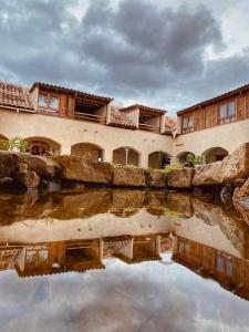 een reflectie van een gebouw in een waterlichaam bij Hotel Junvay in San Cristóbal de Las Casas