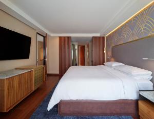 a bedroom with a large bed and a flat screen tv at Grand Fiesta Americana Chapultepec in Mexico City