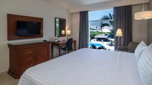 a hotel room with a bed and a desk and a television at Holiday Inn Tuxtla Gutierrez, an IHG Hotel in Tuxtla Gutiérrez