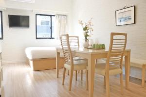 a dining room with a table and chairs and a bed at Petit Grande Miyabi in Tokyo