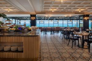 un ristorante con bar, tavoli e sedie di Resort Hadera by Jacob Hotels a Hadera