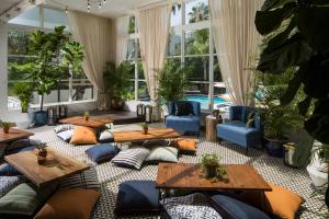 a living room with tables and couches and plants at Generator Miami in Miami Beach