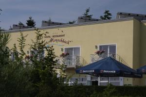 un bâtiment jaune avec une tente bleue devant lui dans l'établissement Zur Morschbach, à Altlay