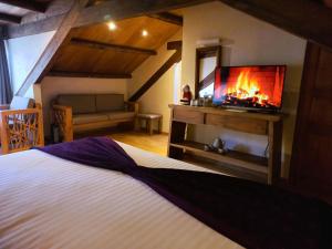 een slaapkamer met een bed, een open haard en een televisie bij Hotel Junvay in San Cristóbal de Las Casas