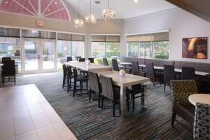 a dining room with tables and chairs and windows at Sonesta ES Suites Dallas Medical Market Center in Dallas