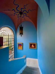 a hallway with blue walls and a ceiling with a chandelier at PALAZZO FIACCADORI - Historical Palace in Reggio di Calabria