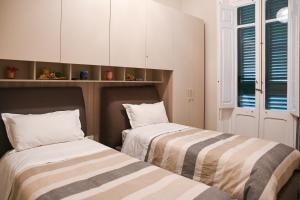 two beds sitting next to each other in a room at Xenia Home in Reggio di Calabria