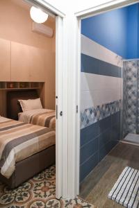 a bedroom with two beds and a shower at Xenia Home in Reggio di Calabria