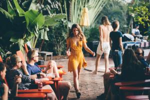 a woman in a yellow dress walking down a street at Freehand Miami in Miami Beach