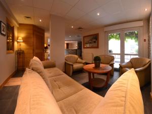 a living room with a large couch and a table at Hotel Les Terrasses in Annecy