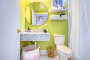 a bathroom with a sink and a toilet and a mirror at The Oleander Hotel Room 6 in Galveston