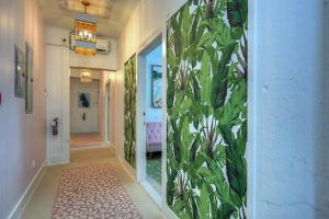 a hallway with a mural of leaves on the wall at The Oleander Hotel Room 6 in Galveston