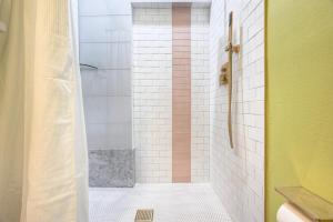 a bathroom with a shower with a white and pink at The Oleander Hotel Room 6 in Galveston