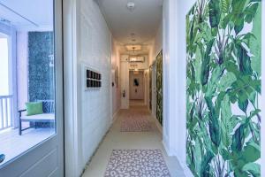 a hallway with a plant mural on the wall at The Oleander Hotel Room 6 in Galveston