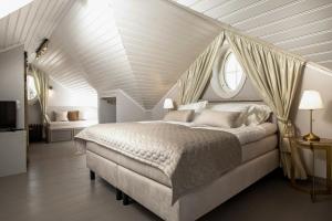 a bedroom with a large white bed and two windows at Lilla Sand in Porvoo