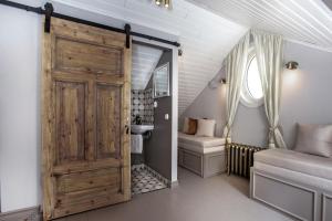 a bathroom with a wooden door and a sink in a room at Lilla Sand in Porvoo