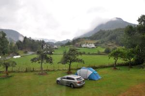 un'auto parcheggiata in un campo vicino a una tenda di Kyrping Camping a Kyrping