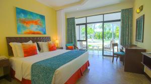 a hotel room with a bed and a sliding glass door at Sarova Whitesands Beach Resort & Spa in Mombasa