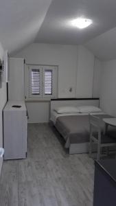 um quarto com uma cama, uma secretária e uma mesa em EMA HOUSE em Zadar