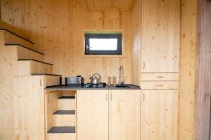 cocina con paredes de madera y encimera con fregadero en Tiny House Nature 14 Zur Meerseite - Green Tiny Village Harlesiel, en Carolinensiel