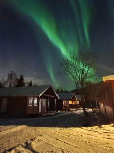 une image de l'aurore dans le ciel sur un bâtiment dans l'établissement Lofoten Camp, à Stamsund