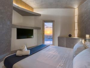 a bedroom with a large bed with a flat screen tv at Alma Calma Hotel Rural in Tindaya