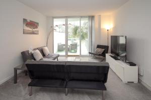 a living room with a couch and a flat screen tv at Ocean Reserve - Park View 1 Bedroom in Miami Beach