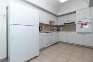 a kitchen with white cabinets and a white refrigerator at Ocean Reserve - Park View 1 Bedroom in Miami Beach